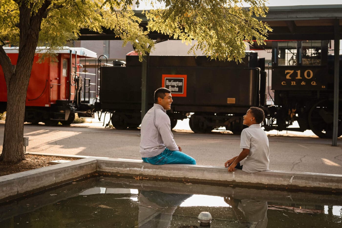 Male mentor and mentee sit and talk with eachother.