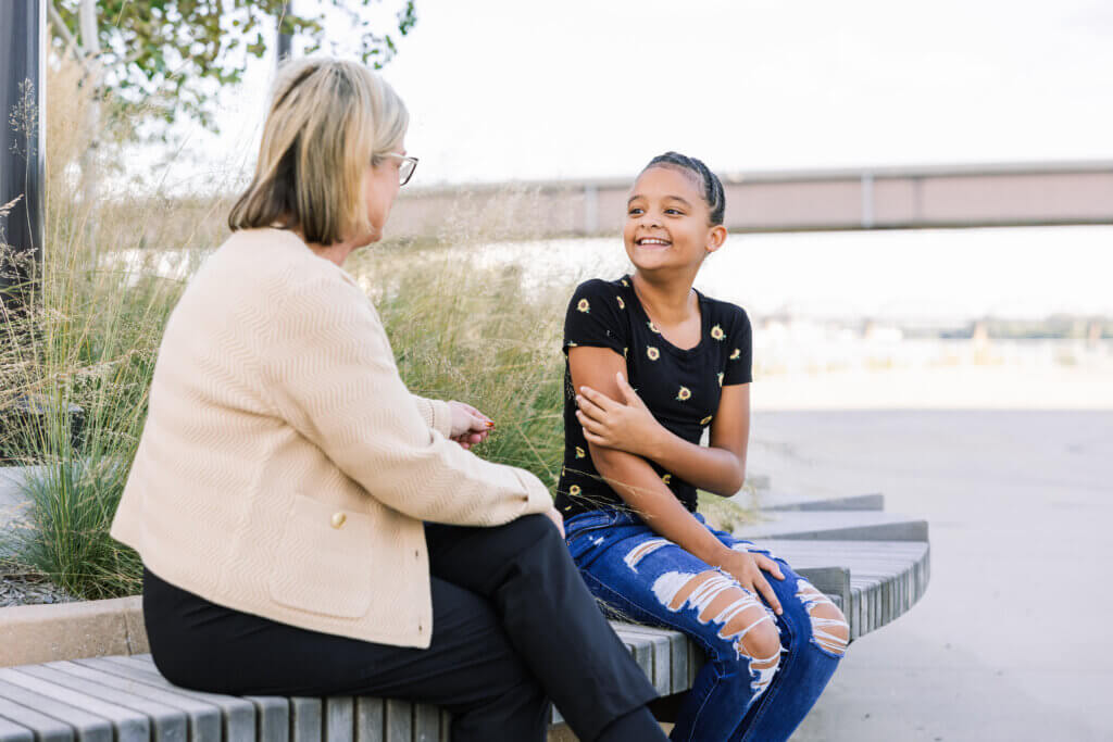 Mentor and mentee talking on a bench outside